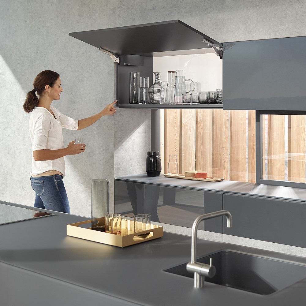 A women operating a Blum AVENTOS lift system